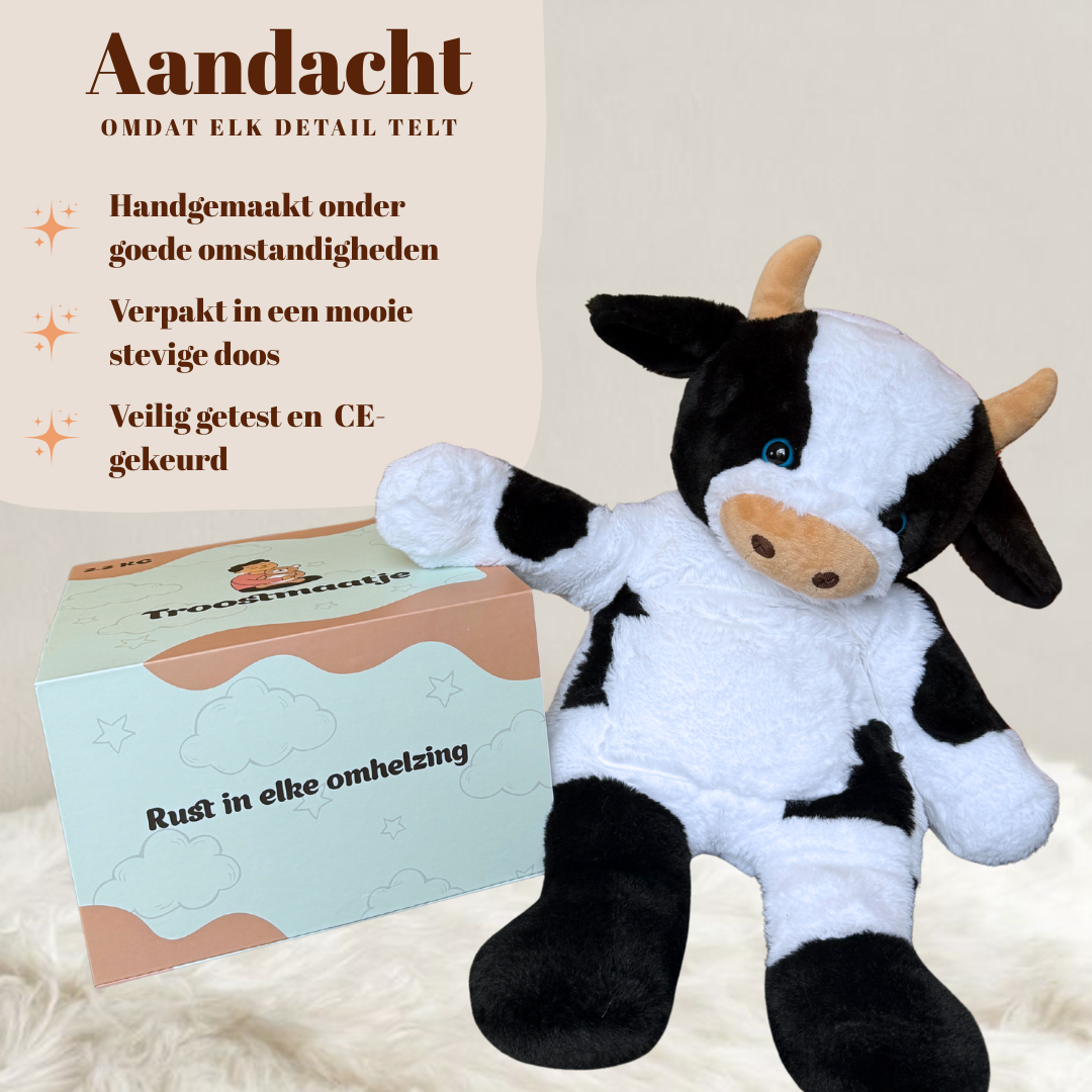 De verzwaarde koe knuffel naast de luxe geschenkverpakking; handgemaakt onder eerlijke omstandigheden.