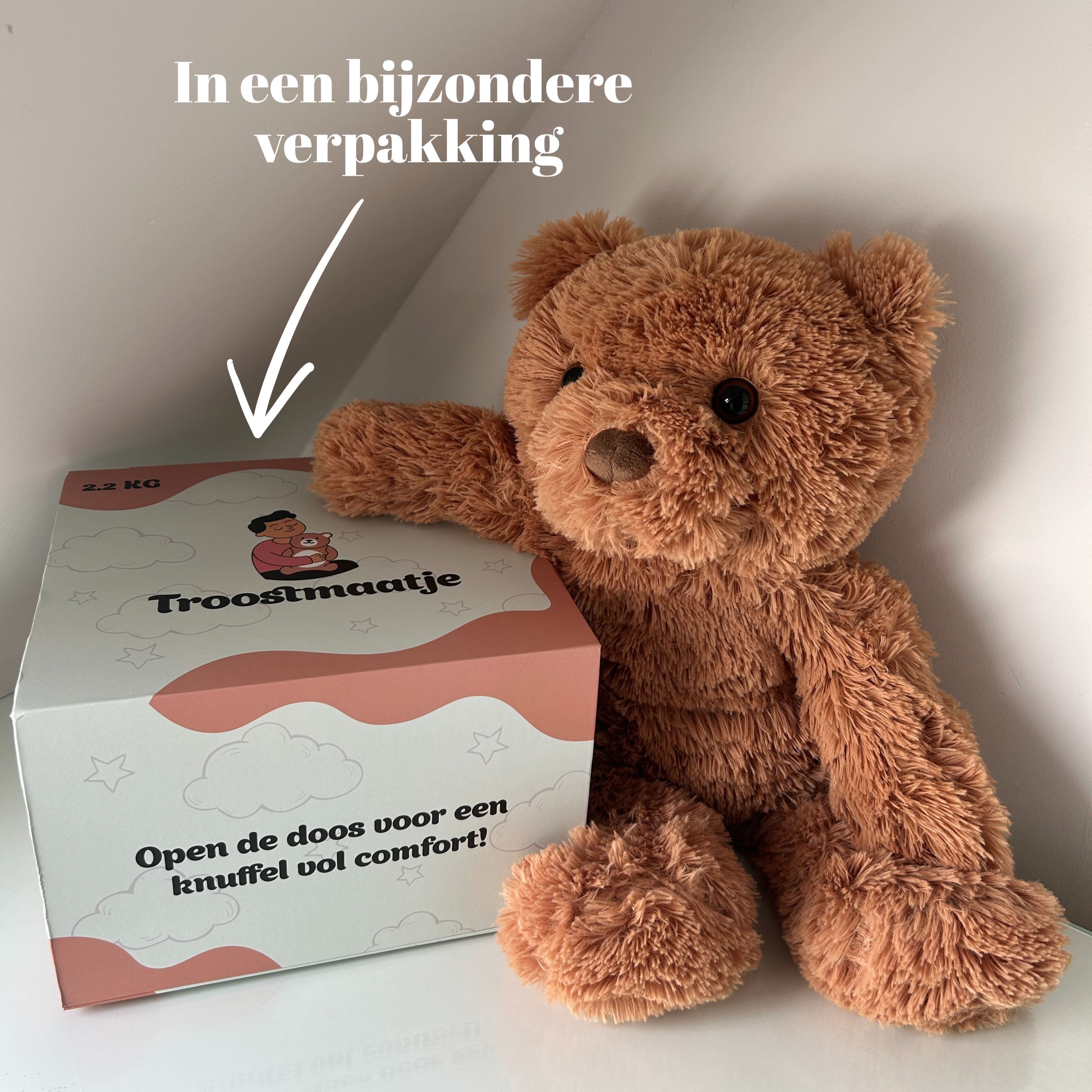 Bruine verzwaringsknuffel beer naast een luxe "Troostmaatje" geschenkdoos met de tekst 'Open de doos voor een knuffel vol comfort!'.