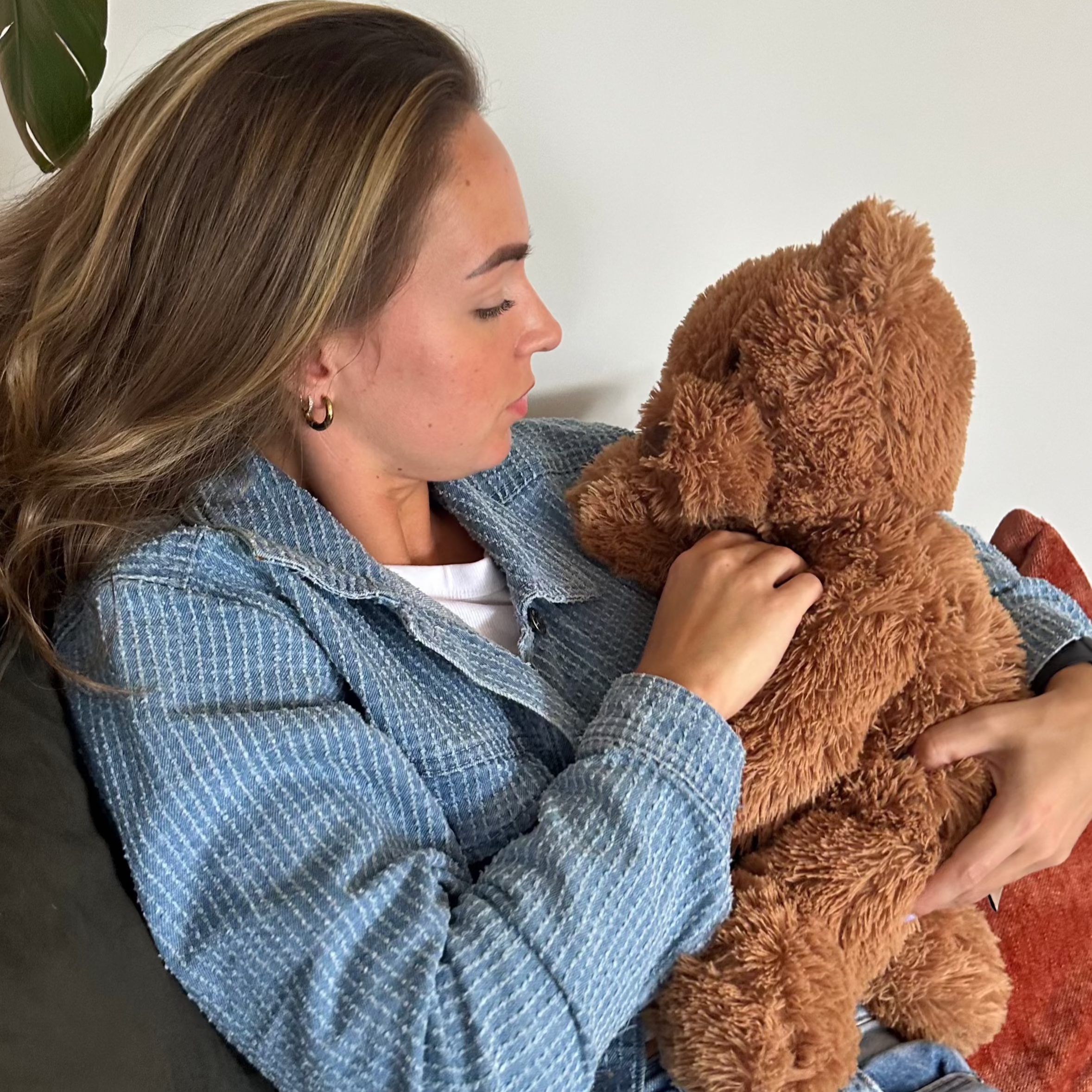 Vrouw die met gesloten ogen rust vindt bij de zachte bruine verzwaarde beer.